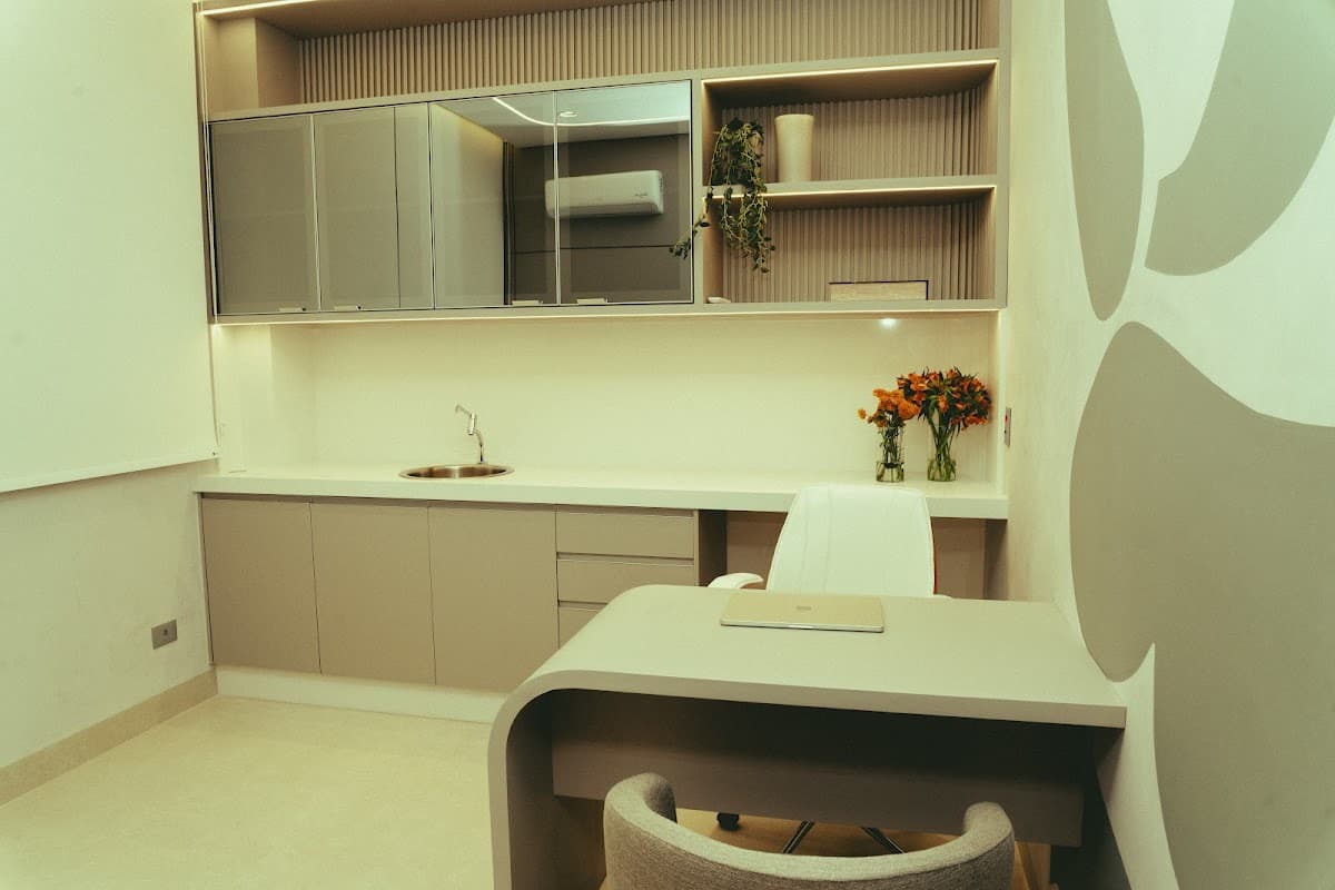 Consultório bem iluminado e organizado, com móveis modernos.